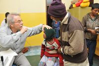 Der Augenarzt Dr. Albrecht Hennig untersucht die siebenjährige Rita nach ihrer Augenoperation.