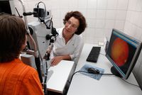 Eine Augenärztin untersucht den Augenhintergrund bei einer Patientin