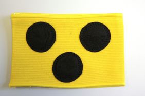 Die gelbe Armbinde mit drei schwarzen Punkten. Die Armbinde für blinde und sehbehinderte Menschen.