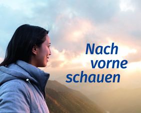 Das Motiv 2019 zeigt auf der linken Seite eine Frau mit langen schwarzen Haaren und einer blau-grauen Jacke im Seitenprofil. Sie lächelt leicht, ihr Blick ist nach rechts in die Ferne gerichtet. Am unteren rechten Bildrand ist ein sonnendurchflutetes Tal zu erkennen, die Hügel sind bewaldet. Darüber sind hellgraue Wolken zu erkennen durch die die Sonne hindurch scheint. Auf Höhe der Sonne ist in der rechten Hälfte des Motivs das Thema der diesjährigen Aktionswoche „Nach vorne schauen“ in drei Zeilen und blauer Schrift platziert.