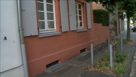 Ausschnitt aus dem Simulationsfilm der Woche des Sehens. Blick auf einen Gehsteig und eine Hauswand. Der Fahrradfahrer ist nicht zu sehen.