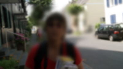 Portrait einer Frau auf einer Straße. Seheindruck mit Altersabhängiger Makula-Degeneration. Das Zentrum des Sichtfeldes ist unscharf 