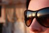 rechte Bildhälfte Augen- und Nasenpartie eines Frauengesichts mit dunkler Sonnenbrille